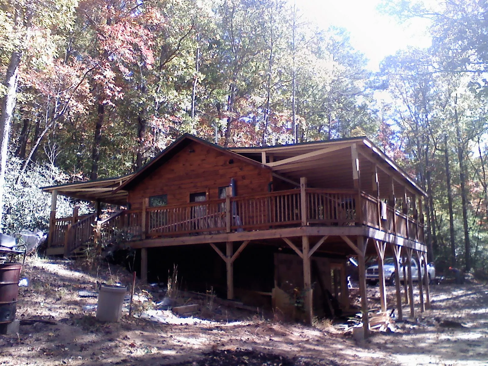 Log cabin with a wraparound porch and metal roof in the fall in Hampton